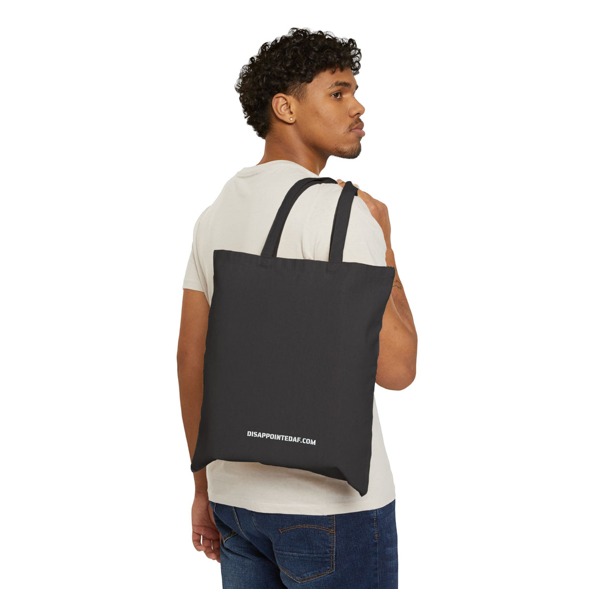 Man carrying a black tote bag on a white background. At the bottom of the tote bag, the URL DisappointedAF.com is printed in white ink.