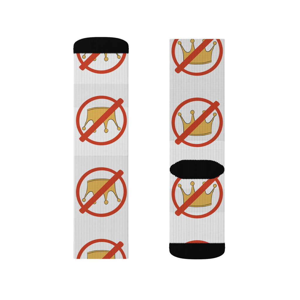 A pair of crew socks worn on legs, featuring a white ribbed base with a repeating graphic of a gold crown inside a red prohibition symbol, finished with black heels and toes.
