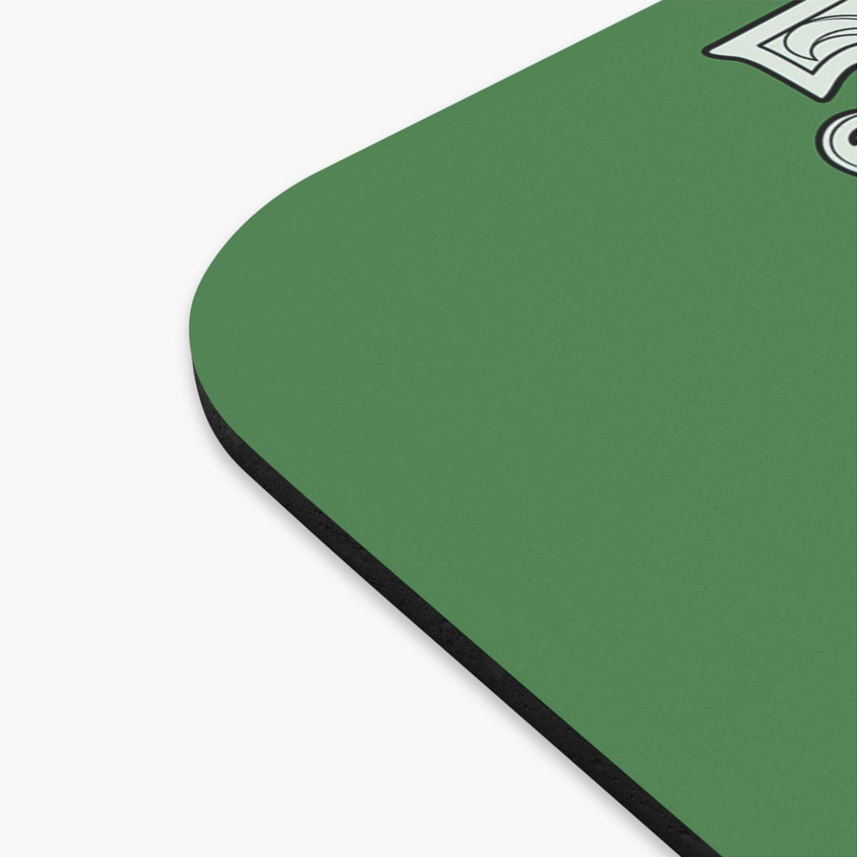 Close-up of a green rounded-corner product surface with a black edge and part of a white graphic near the top right, shown on a light gray background.